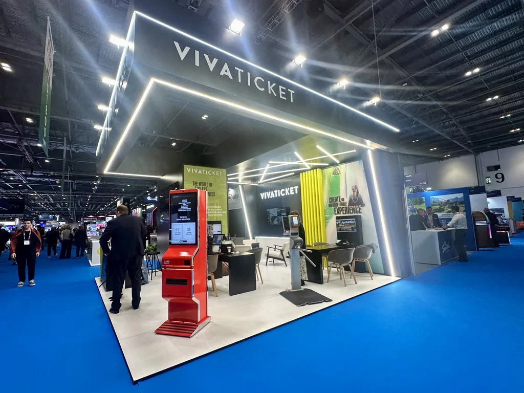 Stand de Vivaticket en IAAPA Expo Europe 2026 con marco negro iluminado, quiosco rojo y torno de acceso