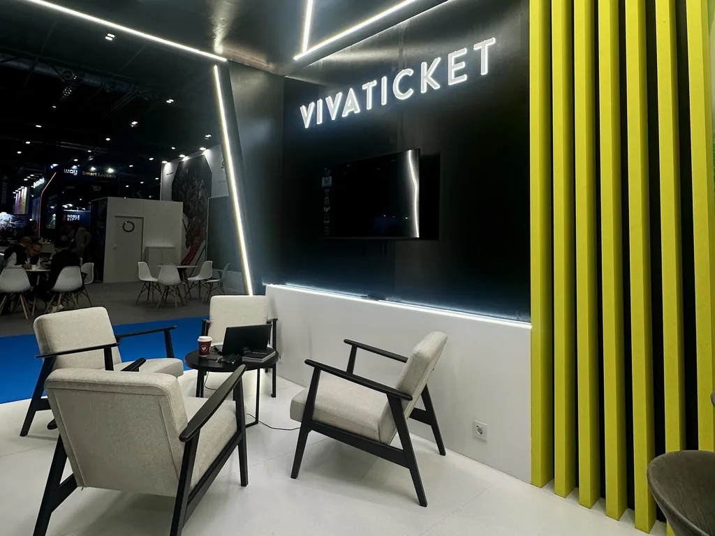 Zona de reunión del stand de Vivaticket con sillones, techo de líneas LED y lamas verde lima